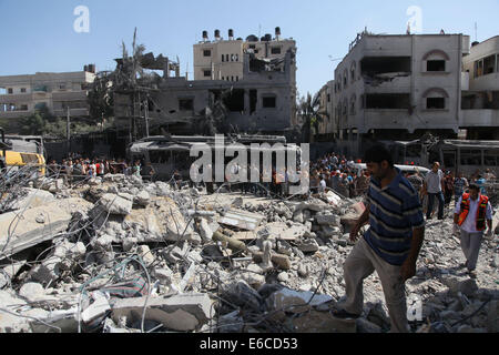 Gaza, bande de Gaza, territoire palestinien. 20e Août, 2014. Les Palestiniens se tenir en face d'un bus que des témoins ont dit a été détruit lors d'une attaque aérienne israélienne à Gaza le 20 août 2014. Credit : ZUMA Press, Inc./Alamy Live News Banque D'Images