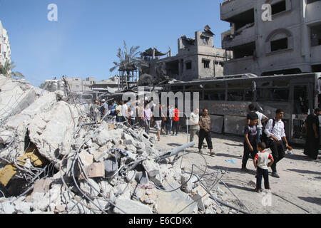 Gaza, bande de Gaza, territoire palestinien. 20e Août, 2014. Les Palestiniens se tenir en face d'un bus que des témoins ont dit a été détruit lors d'une attaque aérienne israélienne à Gaza le 20 août 2014. Credit : ZUMA Press, Inc./Alamy Live News Banque D'Images