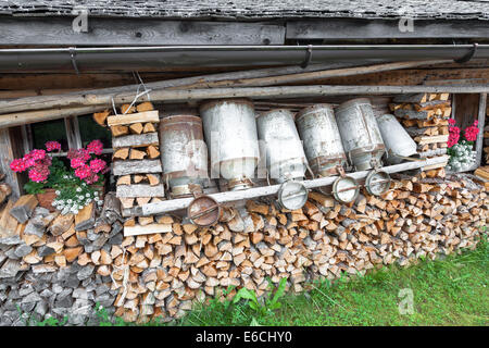 Vieux bidons de lait et bois dans un chalet de montagne Banque D'Images