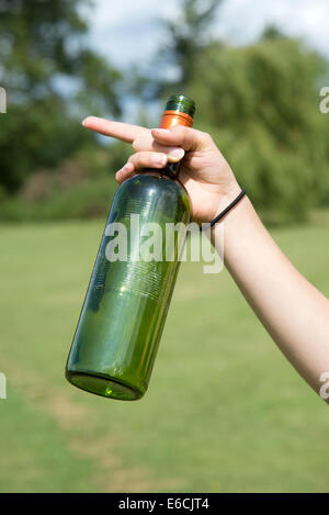 Woman's hand holding empty wine et les bouteilles de bière d'être recyclé Banque D'Images