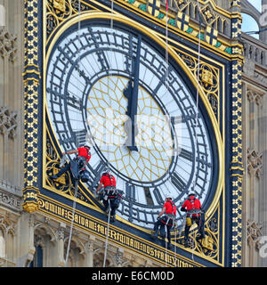 Groupe de nettoyeurs qui détournent Big Ben pour nettoyer le célèbre cadran de l'horloge avec les mains réglées à l'heure fausse de 12 heures ou minuit Westminster Londres Angleterre Royaume-Uni Banque D'Images