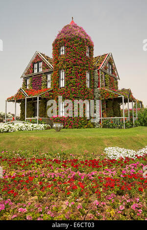 Floral spectaculaire display, maison créée avec des masses de fleurs rouge et vert le feuillage à Dubaï Miracle Jardins en désert de l'eau Banque D'Images