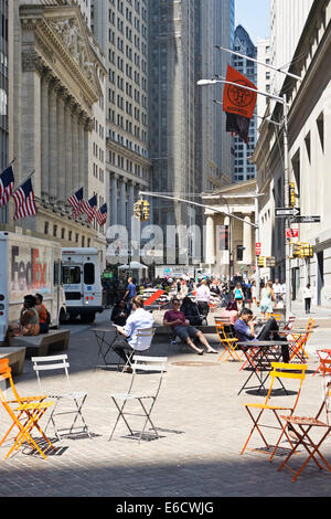 Scène d'été urbain paisible comme personnes lounge dans soleil sur le mobilier urbain dans la zone piétonne en face de New York Stock Exchange Banque D'Images