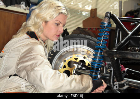 Woman fixing sa voiture de course midget Banque D'Images