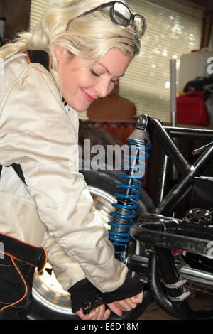 Woman fixing sa voiture de course midget Banque D'Images