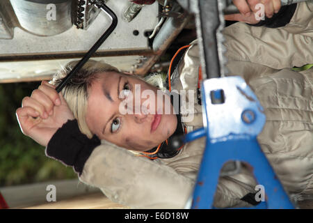 Woman fixing sa voiture de course midget Banque D'Images