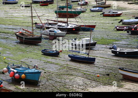 Une flottille de petits bateaux de pêche dans le port Mousehole attendent la marée pour entrer. Banque D'Images