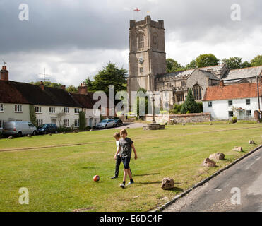 L'église de St Michael et le beurre, une croix sur le village vert dans Aldbourne, Wiltshire, Angleterre Banque D'Images