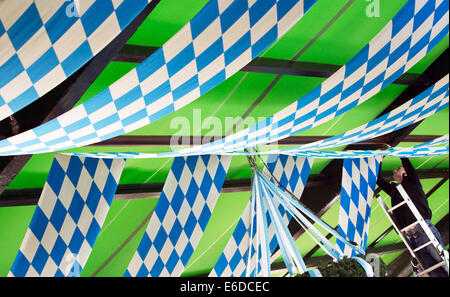 Munich, Allemagne. 21e Août, 2014. Un travailleur orne le toit d'une tente au cours de la présentation de la nouvelle Wies'n Beer mug pour 2014 à l'Oktoberfest sur la Theresienwiese à Munich, Allemagne, 21 août 2014. L'Oktoberfest a lieu du 20 septembre au 05 octobre de cette année. Photo : PETER KNEFFEL/dpa/Alamy Live News Banque D'Images