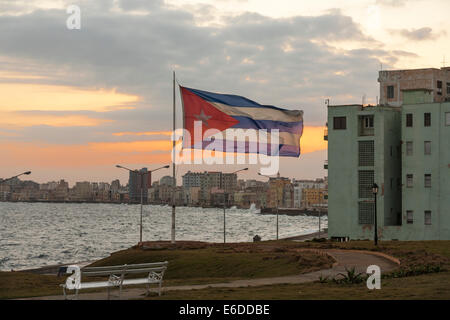 Drapeau national cubain par vent fort, des vagues se briser sur le Malecon, La Havane, Cuba le soir au coucher du soleil Banque D'Images