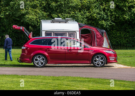 Un vieux / vieille / senior lady marche loin de sa caravane et voiture sur un emplacement camping Caravan Club en Angleterre, Royaume-Uni. Banque D'Images