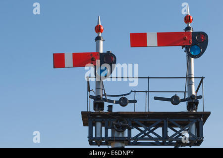 Vintage train britannique dans la position d'arrêt du signal sur la West Somerset Railway, contre ciel bleu clair. Banque D'Images