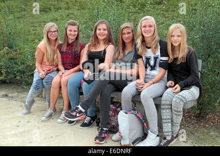 Un groupe de six adolescentes assis sur un banc de parc à Neerpelt, près de Lommel juste au sud de la frontière belgo-néerlandaise. Banque D'Images