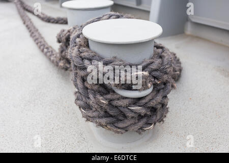 Close-up d'une corde d'amarrage avec une extrémité nouée autour d'un crochet attaché sur une jetée en bois/ amarre Nautique Banque D'Images