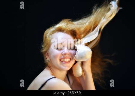 Portrait d'une jeune adolescente ballerina holding sa pointe chaussures de ballet. Banque D'Images