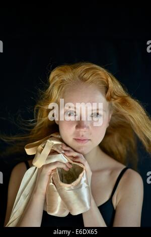 Portrait d'une jeune adolescente ballerina holding sa pointe chaussures de ballet. Banque D'Images