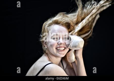 Portrait d'une jeune adolescente ballerina holding sa pointe chaussures de ballet. Banque D'Images