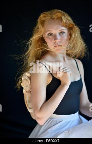 Portrait d'une jeune adolescente ballerina holding sa pointe chaussures de ballet. Banque D'Images