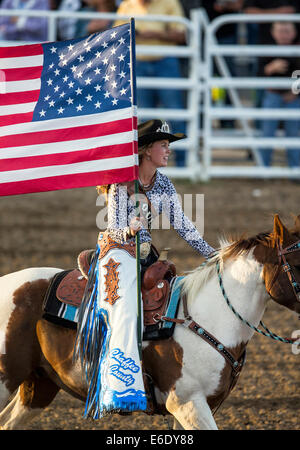 Rodeo Reine exerçant son drapeau américain à cheval pendant l'hymne national, Chaffee County Fair & Rodeo, Colorado, USA Banque D'Images