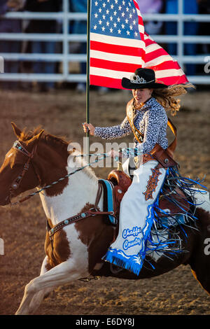 Rodeo Reine exerçant son drapeau américain à cheval pendant l'hymne national, Chaffee County Fair & Rodeo, Colorado, USA Banque D'Images