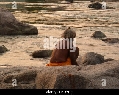 Saddhu dans la rivière entre les rochers sur les rives de la rivière Betwa à Orchha, le Madhya Pradesh, région Bundelkhand, Inde, Asie Banque D'Images