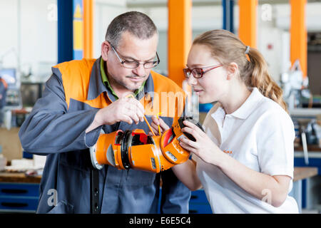 L'explication de l'instructeur un robot part à un stagiaire pour la mécatronique les travaux de montage, centre de formation de l'fabricant de robots KUKA Banque D'Images