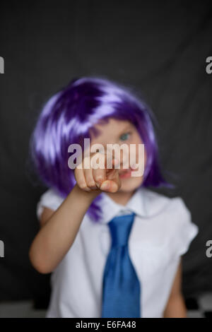 Enfant en chemise et cravate, un doigt pointé vers la caméra effrontément. Banque D'Images