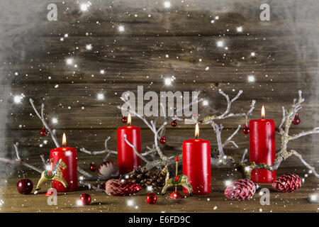 Décoration de Noël en bois sur fond rustique : quatre bougies de l'avent en feu rouge. Pays de neige cadre de style. Banque D'Images