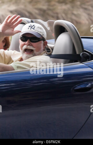 Couple de retraités avec Happy Man Waving roulant Porsche Boxster racé, FL, USA Banque D'Images