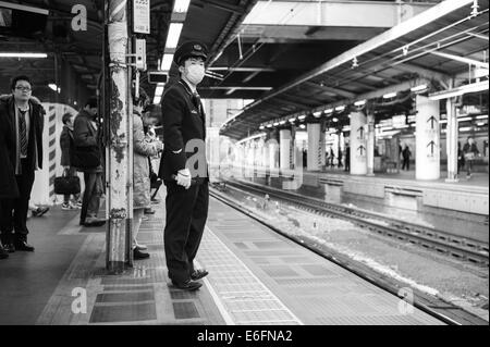 La garde sur la plate-forme à la gare de JR Shinbashi, Tokyo Banque D'Images