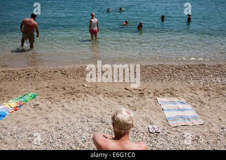 Les gens nager sur une plage à côté du port de Patitiri Alonissos dans sur août 2014. Banque D'Images