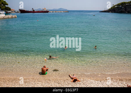 Les gens nager sur une plage à côté du port de Patitiri Alonissos dans sur août 2014. Banque D'Images