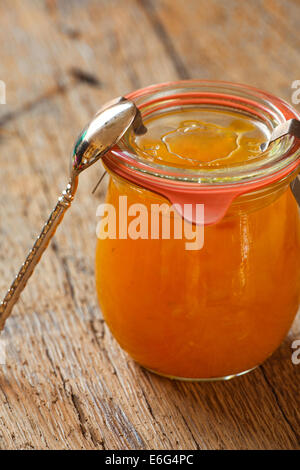 Confiture de melon fait maison dans un bocal avec une cuillère sur la vieille table en bois Banque D'Images