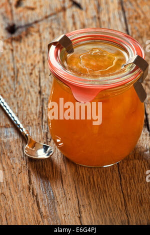 Confiture de melon fait maison dans un bocal avec une cuillère sur la vieille table en bois Banque D'Images