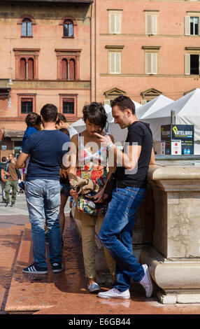 Jeune couple debout près de la fontaine de Neptune de la Piazza del Nettuno, Bologne, Émilie-Romagne, Italie Banque D'Images