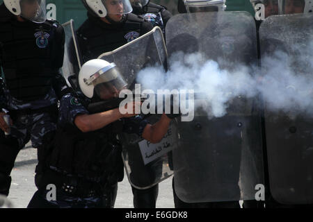 Hébron. 22 août, 2014. Un responsable de la sécurité palestinienne tire quand il tente d'empêcher les Palestiniens d'atteindre un poste de contrôle israélien lors d'un rassemblement dans la ville de Cisjordanie d'Hébron pour soutenir les personnes dans la bande de Gaza, le 22 août, 2014. Credit : Mamoun Wazwaz/Xinhua/Alamy Live News Banque D'Images