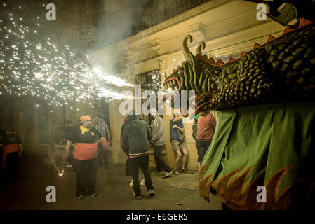Le 'Drac de Gràcia' (Dragon de Gracia) déclenche son artifice parmi la foule des spectateurs de la "Festa Major de Gracia'. © matthi/Alamy Live News Banque D'Images