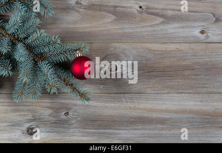 Image horizontale d'une seule de rouge un vrai sapin bleu arbre branche placés sur des planches en bois rustique Banque D'Images