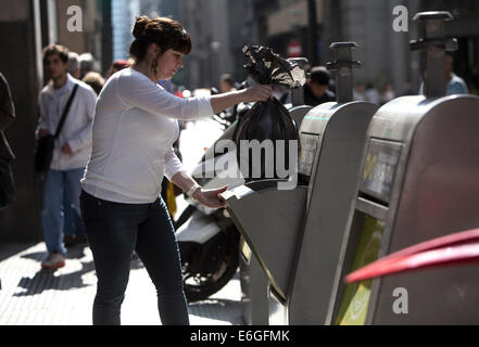 Buenos Aires, Argentine. 22 août, 2014. Une femme jette un sac de déchets dans un conteneur de déchets souterrain dans la ville de Buenos Aires, Argentine, le 22 août 2014. La ville de Buenos Aires a lancé le nouveau système de conteneurs souterrains, une nouvelle modalité qui consiste en l'élimination, le stockage et la collecte des déchets de la chambre, à travers les conteneurs installés sous terre, ce qui permet une grande capacité de collecte des déchets, et qu'il aide dans la réduction des mauvaises odeurs, de prévenir et d'éviter la manipulation, sac de contamination visuelle, selon la presse locale. © Martin Zabala/Xinhua/Alamy Live News Banque D'Images