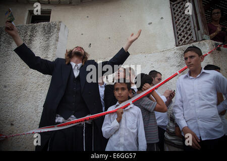 Frontière de Gaza, ville israélienne à la frontière de Gaza. 22 août, 2014. Les Juifs orthodoxes réagir à côté d'une synagogue juive frappée par une roquette lancée de la bande de Gaza à Ashdod, ville israélienne du sud en bordure de Gaza, le 22 août 2014. Un garçon de 4 ans a été tué vendredi soir par un tir de mortier sur le sud d'Israël, Magen David Adom, la Croix-Rouge, dit de Xinhua. © Albert/JINI Sadikov/Xinhua/Alamy Live News Banque D'Images