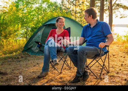 Beau jeune couple assis à côté de la tente Banque D'Images