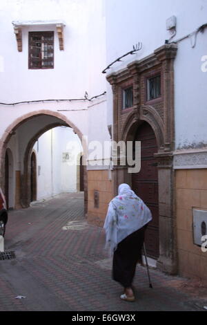 Une photo d'une femme qui se réveille avec peut passer une porte marocaine en bois dans une médina. Image itinérante. Banque D'Images