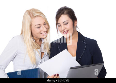 Deux jeunes isolés smiling business woman looking at un livre blanc. Banque D'Images