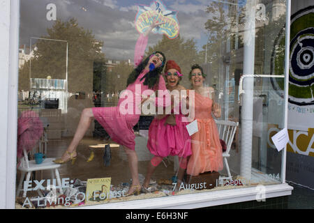 Brighton, UK. 23 août, 2014. Brighton, UK : Artistes Persephone Pearl, Emily Laurens et Rachel effectuer comme Feral Theatre dans la fenêtre de l'Onca Gallery. Se présentant comme birdlife (partie showgirls partie disparue oiseaux.) ces "freaks of nature" doivent être nourris par les membres du public invités à nourrir ces créatures étranges avec les paquets de semences. "Peut-être en échange ils vont chanter et danser, pond un œuf, ou vous invite à pénétrer leur nid." Photo : Richard Baker / Alamy Live News. Banque D'Images