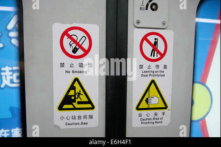 Signes d'avertissement en anglais et en chinois sur le métro de Shanghai, Chine Banque D'Images