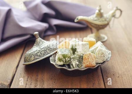 Loukoum avec écrous de métal oriental plat sur fond de bois Banque D'Images