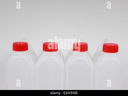 Quatre jerrycans vides de plastique blanc avec couvercle rouge Banque D'Images
