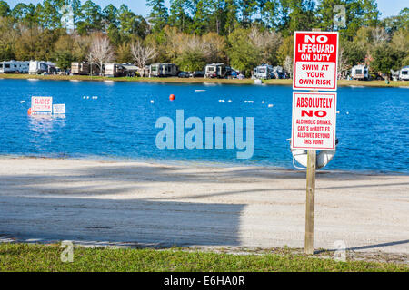 Les panneaux de mise en garde de la baignade à vos risques dans le lac au Flamingo Lake RV Resort à Jacksonville, Floride Banque D'Images