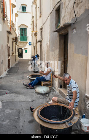 Les pêcheurs préparent leurs lignes dans la vieille ville de Gallipoli, Pouilles, Italie du Sud. Banque D'Images