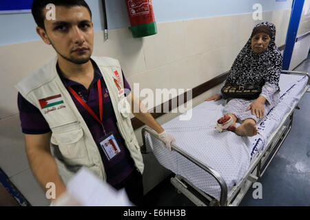 La ville de Gaza, bande de Gaza, territoire palestinien. 24 août, 2014. Une femme palestinienne à roues est de la salle d'urgence à l'hôpital Al-Shifa après qu'il a été blessé au cours d'un bombardement dans la ville de Gaza le 24 août, 2014. L'Égypte a appelé Israël et les Palestiniens le samedi à mettre un terme aux hostilités et à reprendre les pourparlers de paix, mais les deux parties tenues attaques, y compris la frappe aérienne israélienne qui a détruit la tour résidentielle bloc dans le centre de la ville de Gaza Crédit : Mohammed Asad APA/Images/ZUMA/Alamy Fil Live News Banque D'Images